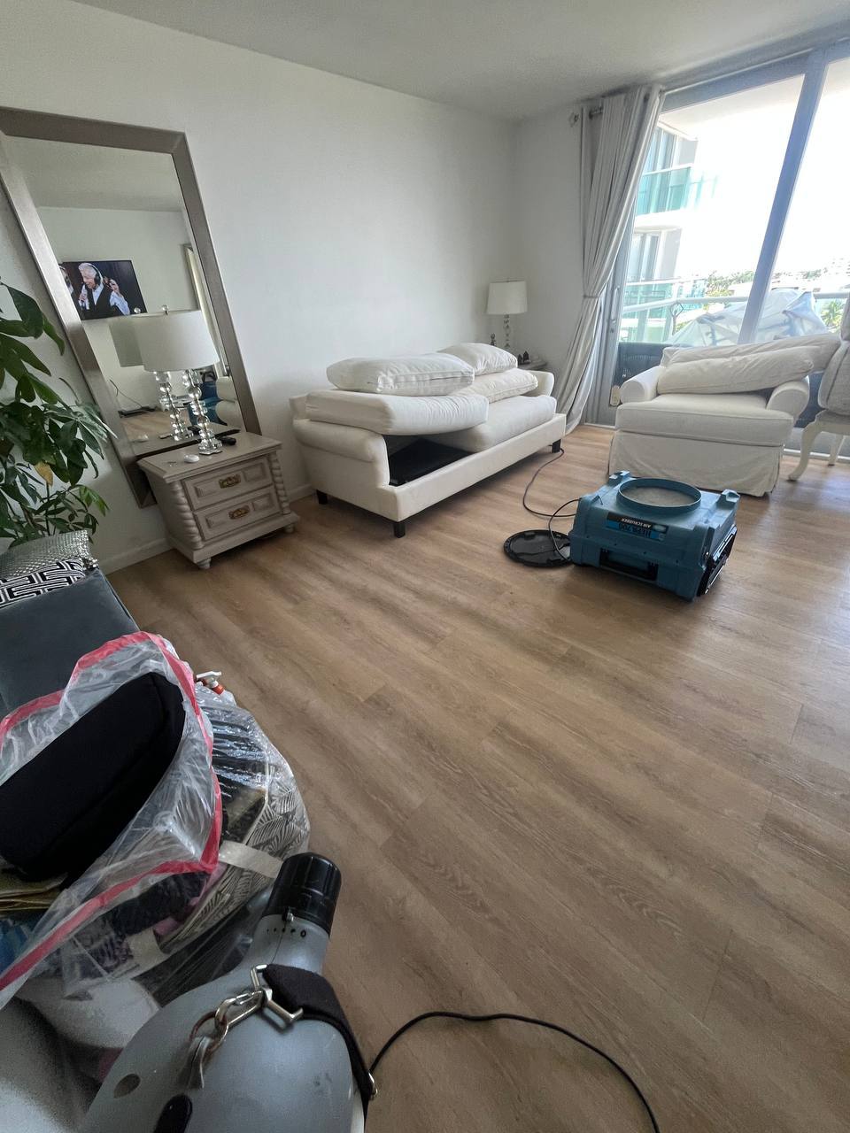 Living room prepared for mold remediation with air-cleaning equipment in use.