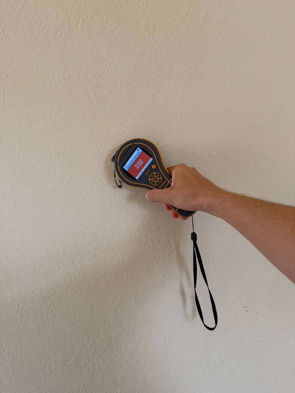 Non-invasive moisture meter detecting high moisture levels inside drywall