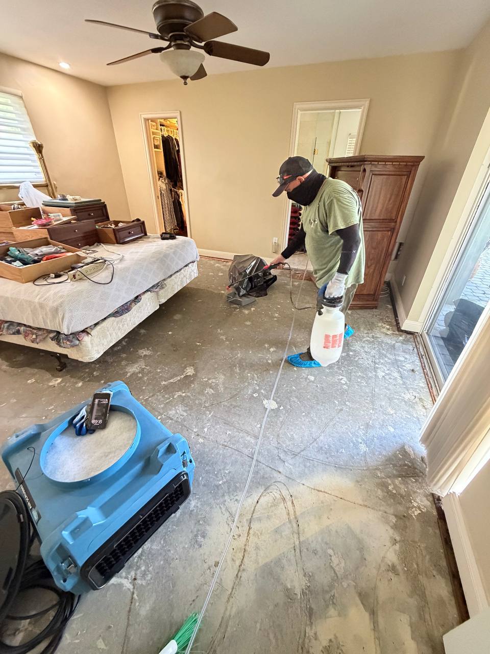 Spraying antimicrobial solution and operating air mover for structural drying