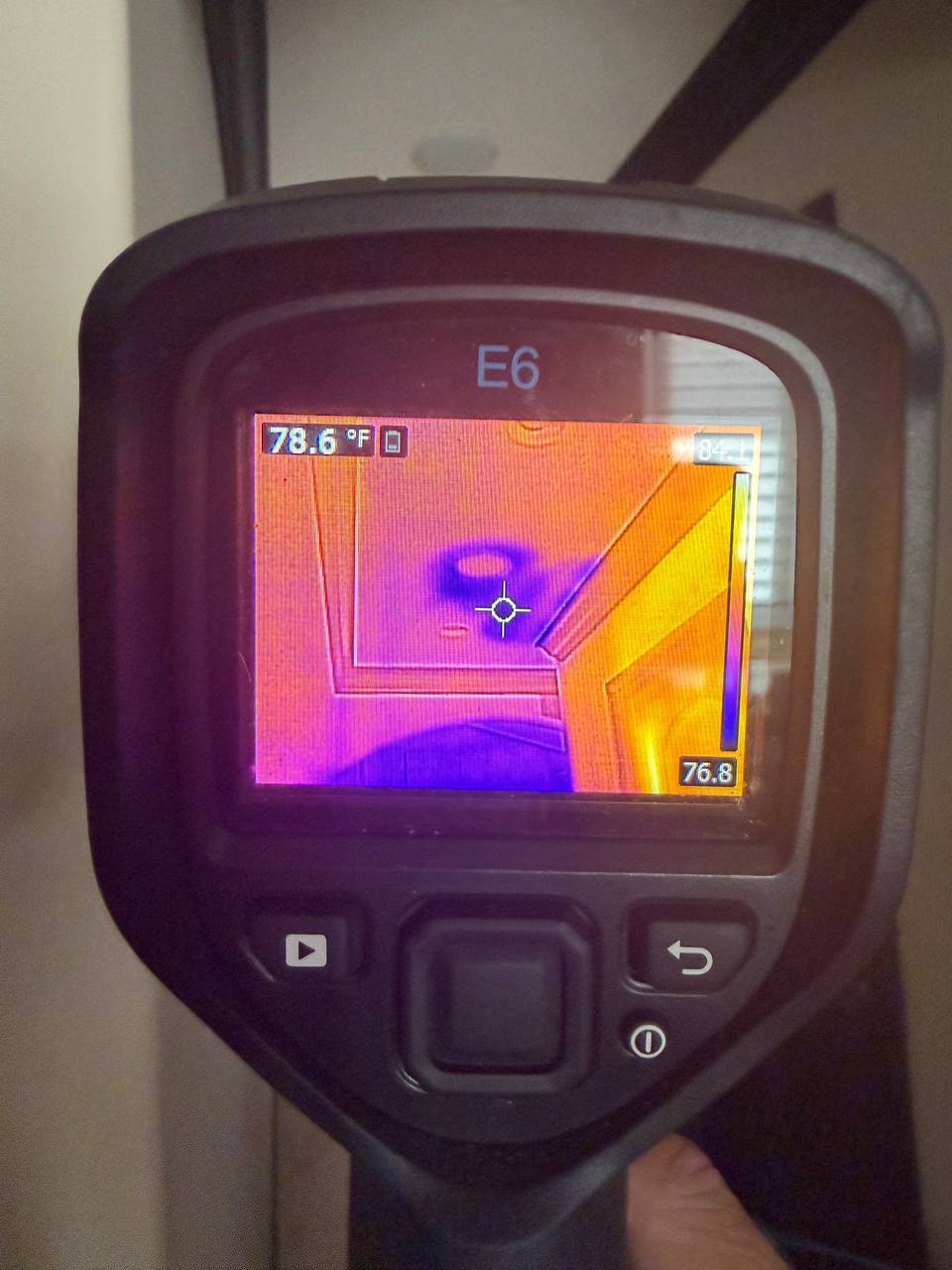 Thermal camera displaying cold moisture patch on drywall near archway header