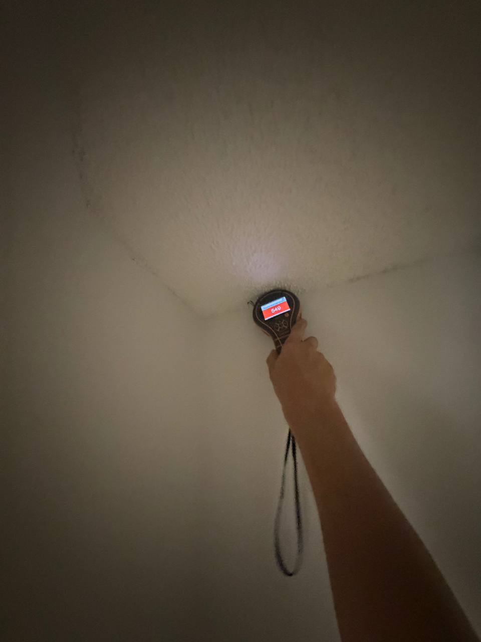 Protimeter gauge confirming high drywall moisture saturation beneath air duct