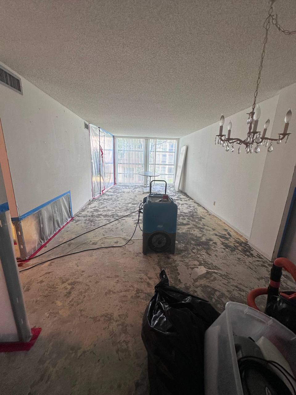 Full living room containment zone with LGR dehumidifier operating during mold remediation