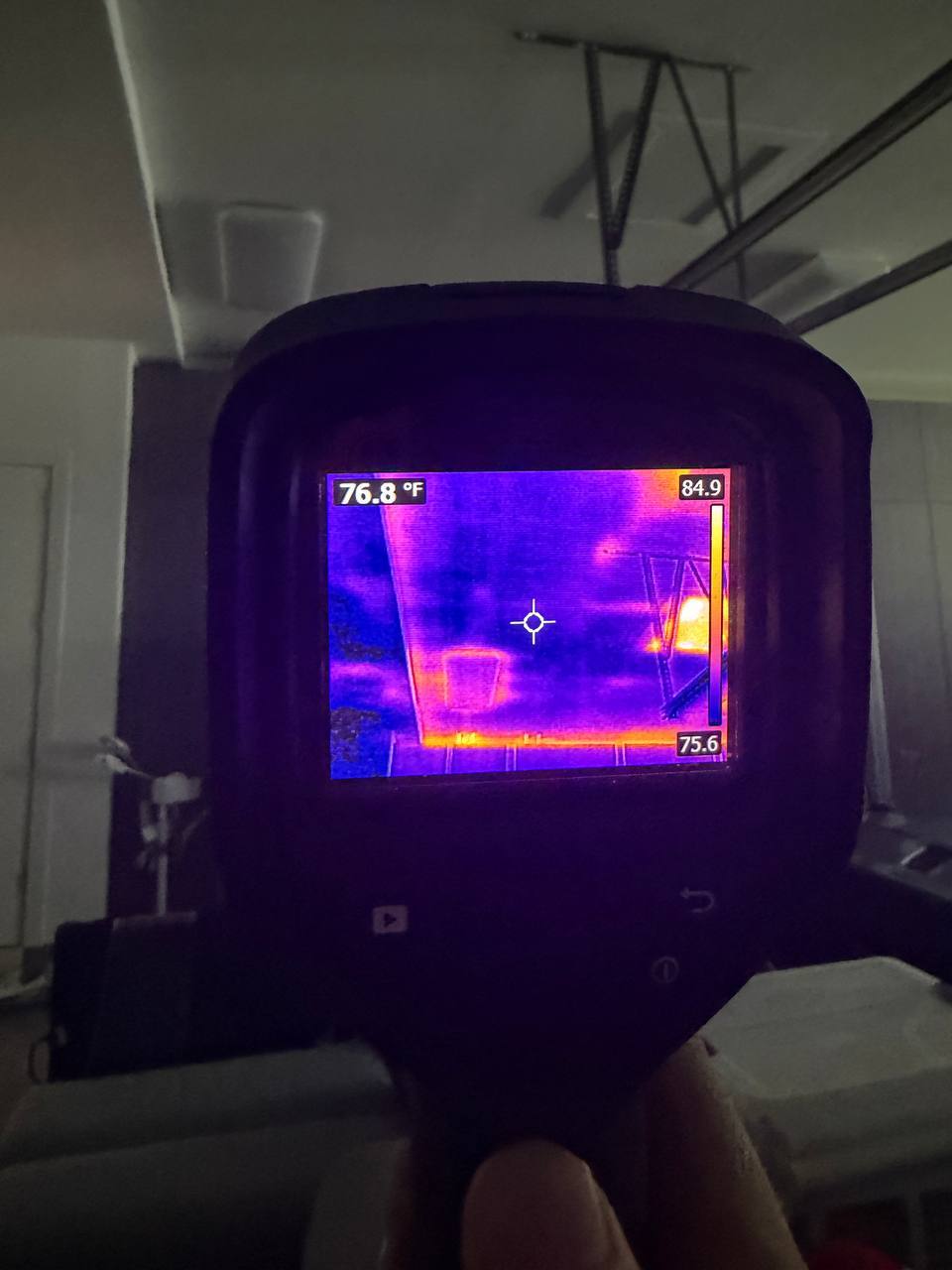 Thermal camera readout identifying temperature differentials and moisture pockets in attic ceiling
