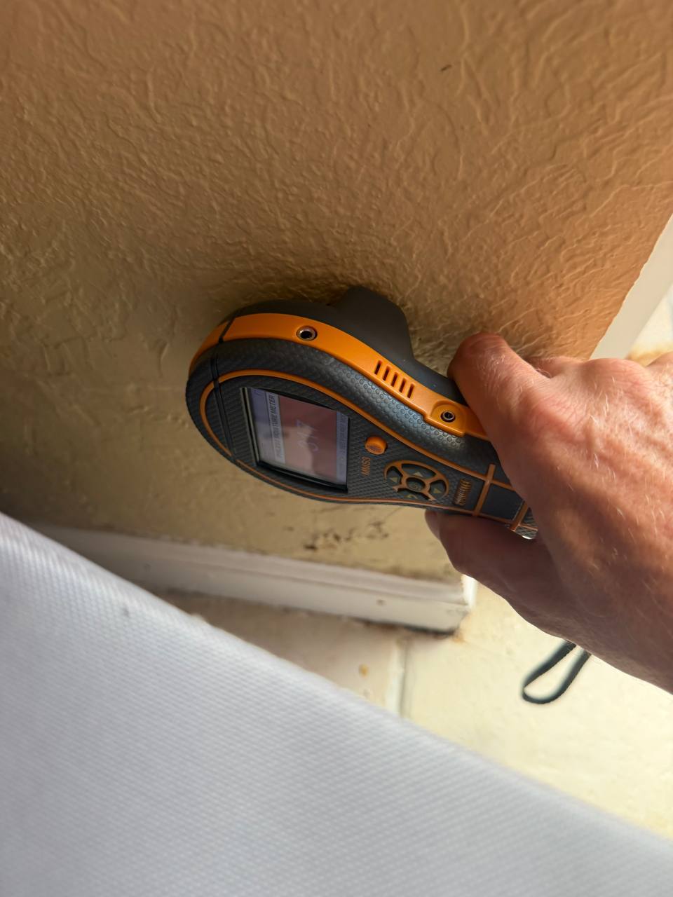 Evaluating drywall moisture levels along interior wall using digital pinless meter