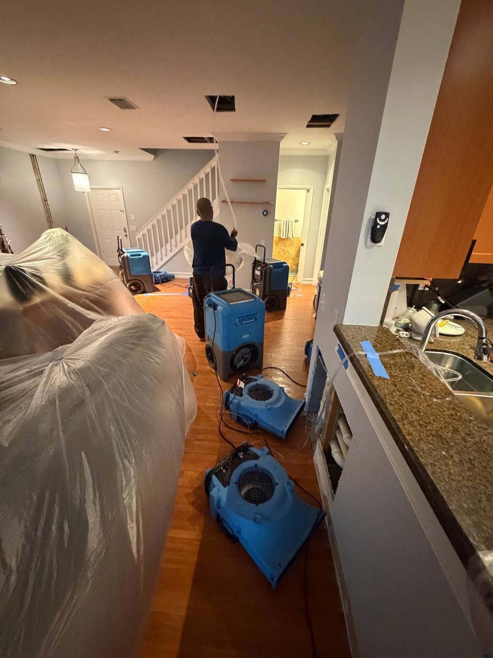 Commercial LGR dehumidifiers and air movers setup on hardwood floor in main living space