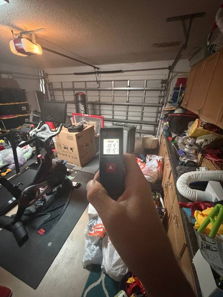 Technician measuring garage area during mold inspection