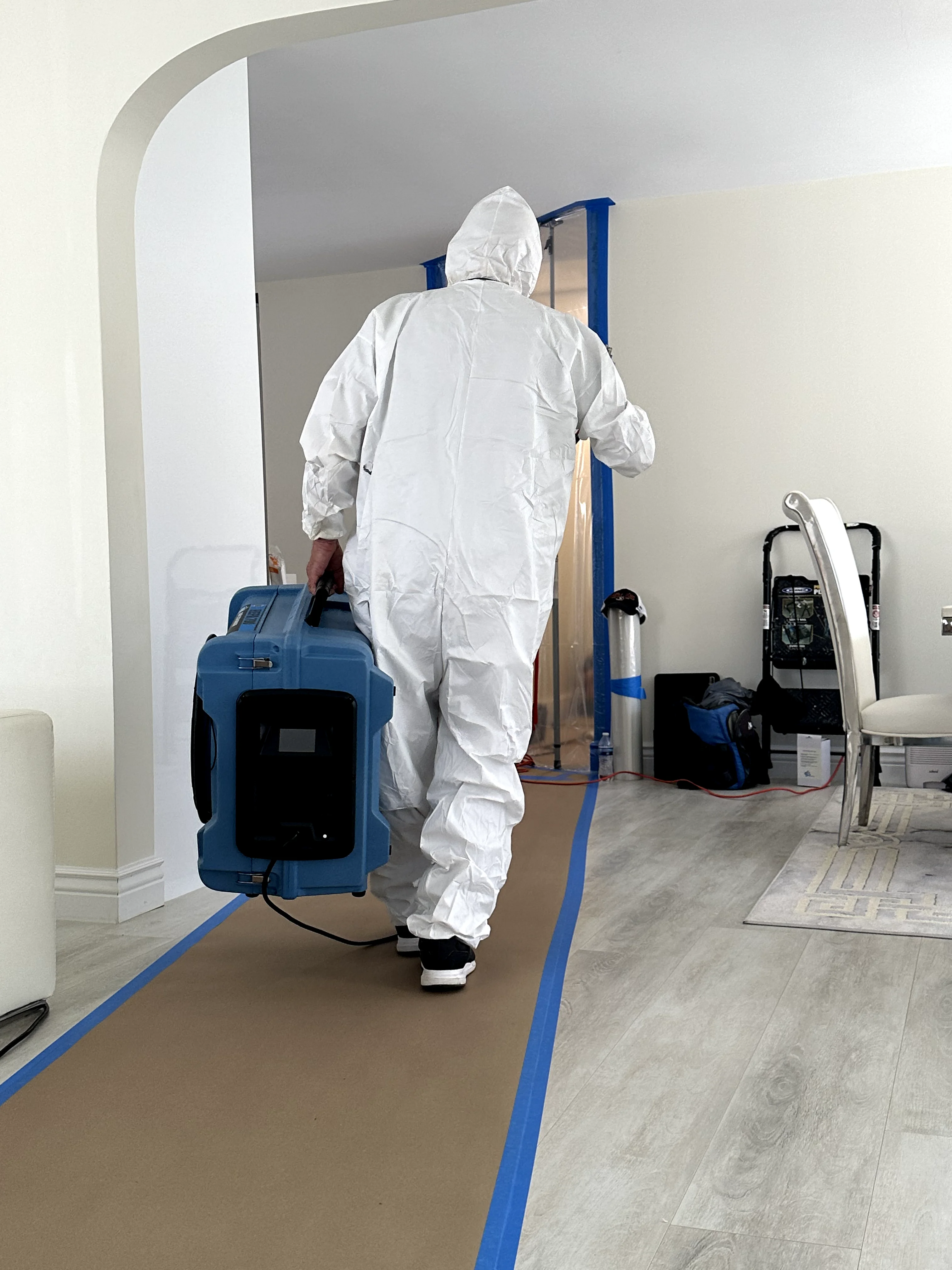 Technician placing an air scrubber in a protected remediation area